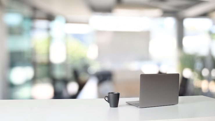 Foto espaço de trabalho com computador portátil e xícara de café na mesa.
