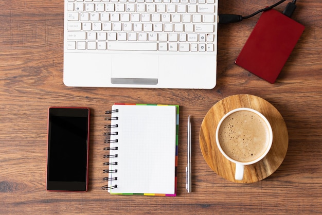 Espaço de trabalho com diário de laptop e uma xícara de café em fundo de madeira Local de trabalho de escritório elegante