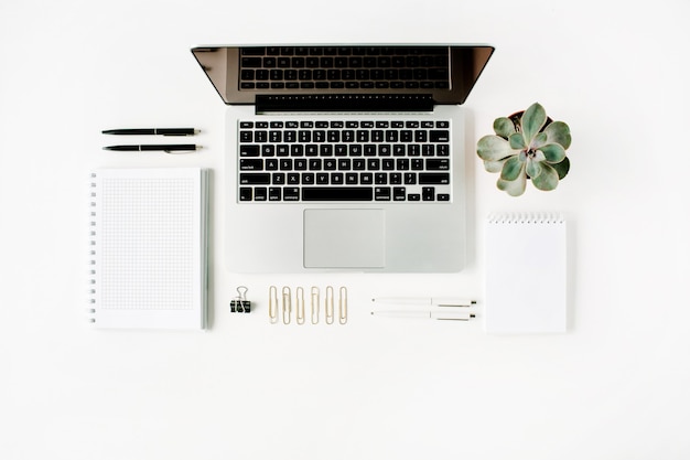 Espaço de trabalho com laptop, diário, suculenta e óculos em branco.