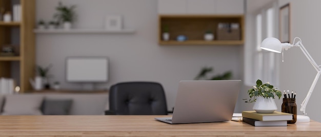Espaço de trabalho com laptop e espaço para cópia na mesa de madeira sobre escritório doméstico moderno desfocado