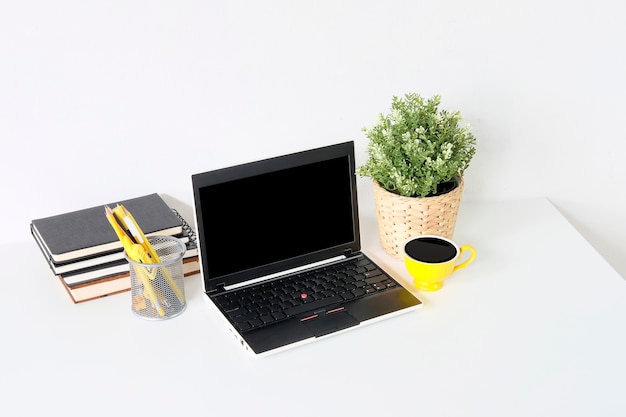 Espaço de trabalho com laptop, material de escritório, decoração de planta na mesa de escritório em casa ou estúdio.