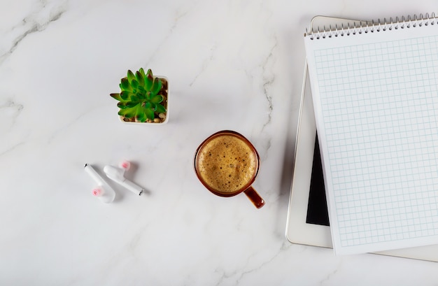 Espaço de trabalho com notebook com fone de ouvido sem fio e café em um tablet digital, mesa de escritório