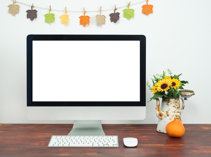 Foto espaço de trabalho com tela de computador em branco e decoração de outono. espaço de trabalho com computador.