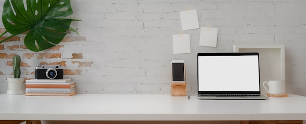 espaço de trabalho confortável com laptop, smartphone, decorações de câmera e espaço para cópia