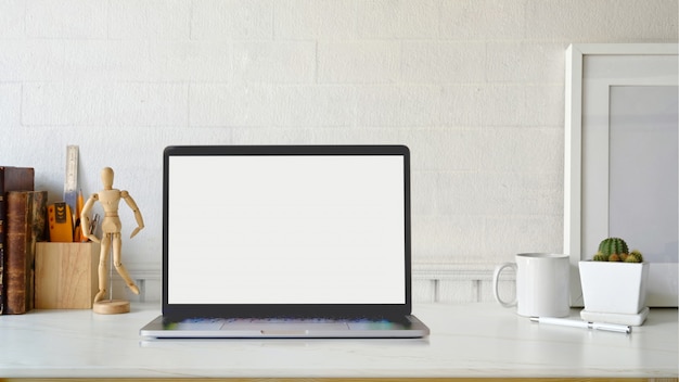 Espaço de trabalho criativo. Cartaz de maquete e laptop na mesa