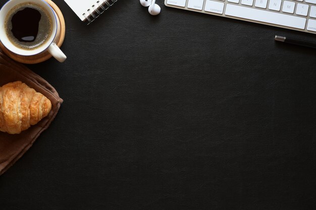 Espaço de trabalho de couro escuro de mesa de escritório com preto café, material de escritório e espaço de cópia