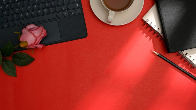 Espaço de trabalho de escritório com teclado sem fio e espaço de cópia na vista superior do fundo da mesa vermelha