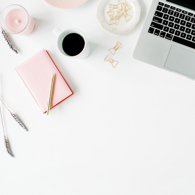 Espaço de trabalho de escritório em casa feminino de moda plana leigos. Laptop, bule rosa, caneta dourada e clipes