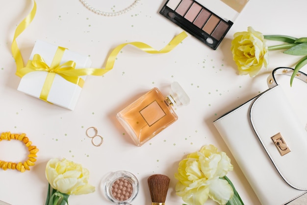 Espaço de trabalho de um blogueiro de moda flores amarelas primavera tulipas cosméticos bolsa feminina caixa de presente