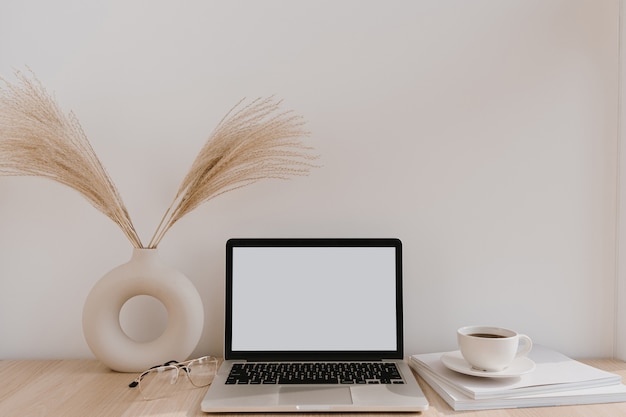 Espaço de trabalho feminino da mesa do escritório em casa. Computador portátil de tela em branco com espaço de cópia.