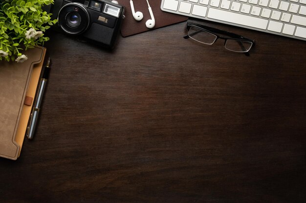 Espaço de trabalho hipster com óculos de câmera retrô e notebook na mesa de madeira Vista superior com espaço de cópia para o seu texto