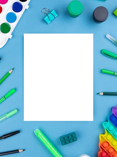 Foto espaço de trabalho infantil claro caderno de esboços caneta pop it lápis borracha de cacto em fundo azul para espaço de cópia