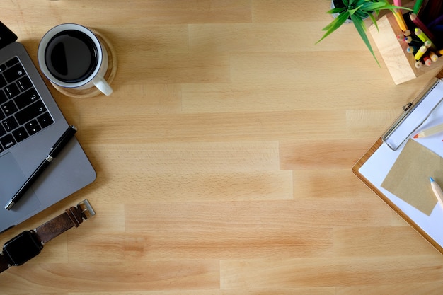 Espaço de trabalho. Laptop, bloco de notas na mesa de madeira