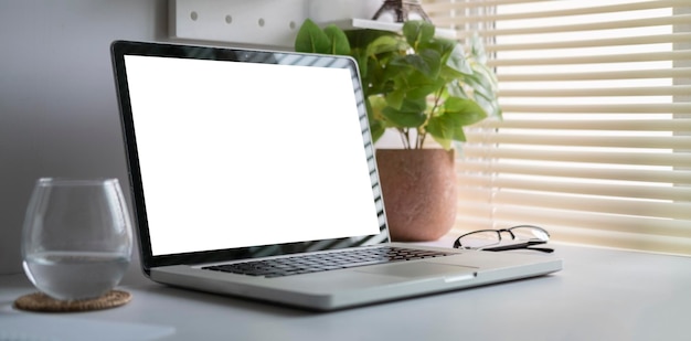 Espaço de trabalho moderno com computador com tela em branco e equipamentos na mesa brancatela em branco para sua informação