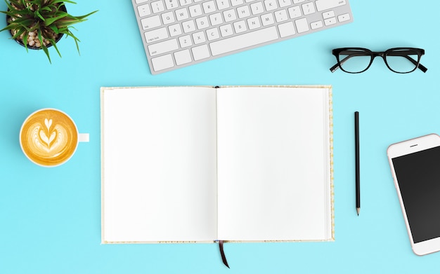 Foto espaço de trabalho moderno com cópia da xícara de café, teclado, notebook aberto e smartphone espaço na cor azul