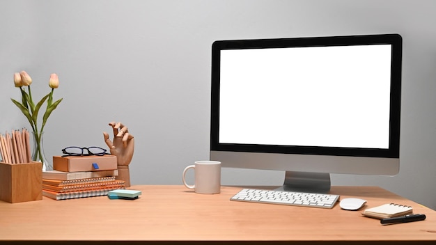 Espaço de trabalho moderno com livros de computador e porta-lápis na mesa de madeira
