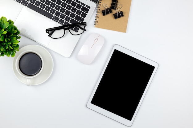 Espaço de trabalho no escritório com tablet e com telas vazias em branco estão no topo