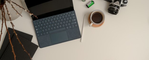 Espaço de trabalho portátil com tablet digital, câmera, xícara de café, notebooks, espaço para decoração e cópia