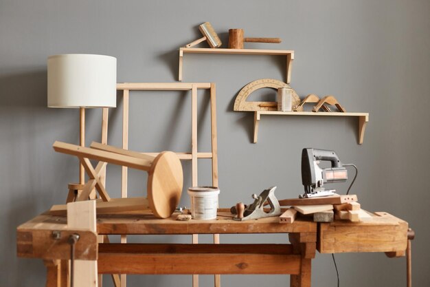 Foto espaço de trabalho vazio da mesa de carpinteiro com ferramentas prateleira de lâmpada de cadeira de madeira no fundo marcenaria vazia