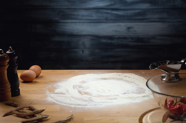 Espaço para cozinhar, farinha na mesa de madeira