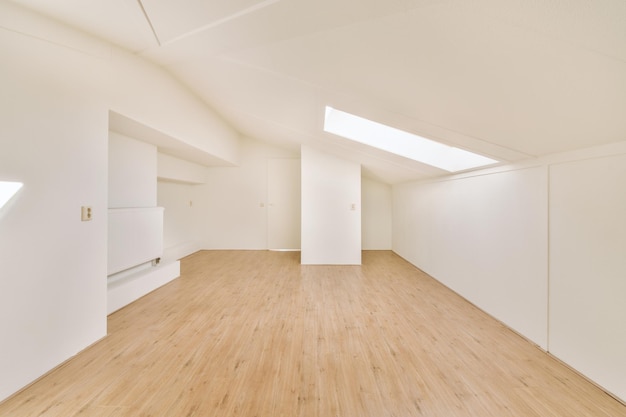 Espaçoso quarto vazio com pisos em parquet e uma pequena janela no telhado de uma casa moderna