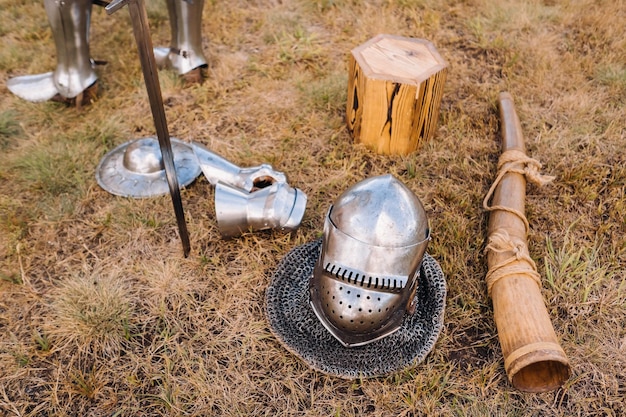 Espada de casco de caballero y cuerno de batalla en el suelo