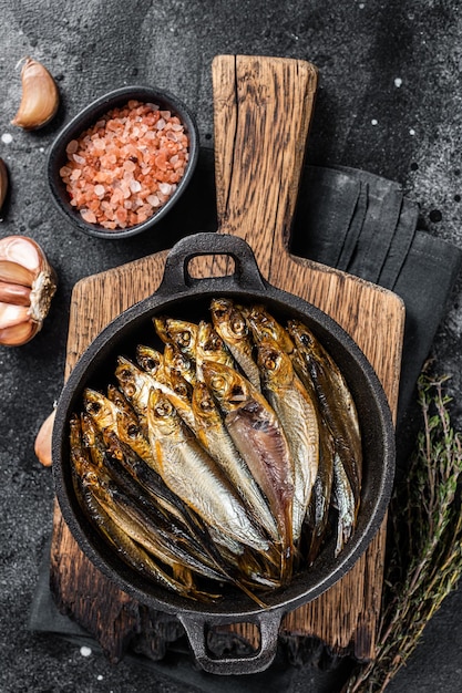 Espadilha defumada quente e peixes de anchova na panela Fundo preto Vista superior