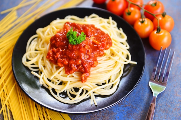 Espaguete à bolonhesa / macarrão italiano de espaguete servido na chapa preta com tomate e salsa no restaurante comida italiana e menu