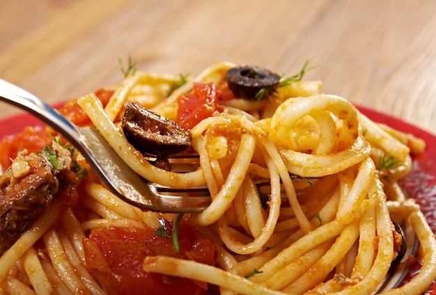 Espaguete alla puttanesca prato de massa italiana salgada. ingredientes são típicos da culinária do sul da Itália: tomate, azeite, azeitonas, alcaparras e alho.