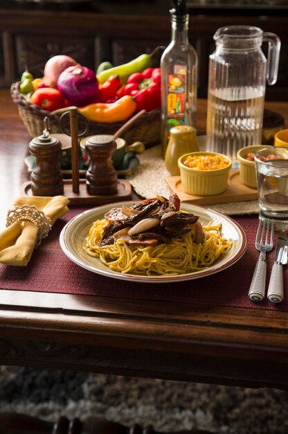 Espaguete ao molho huancaina e lomo saltado Peru peruano comfort food mise en place mesa de madeira