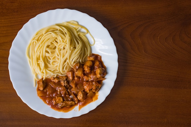 Espaguete com carne de porco em molho de tomate. Comida saborosa