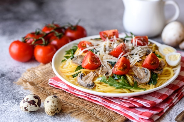 Espaguete com cogumelos, queijo, espinafre, rukkola e tomate cereja. prato italiano, cultura mediterrânea