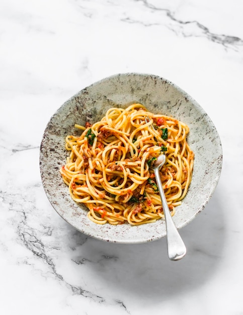 Espaguete com molho de atum enlatado de tomate em uma vista superior de fundo claro