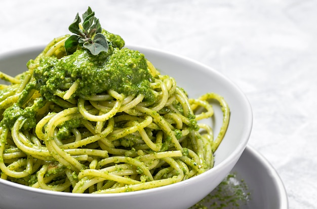 Espaguete com molho pesto caseiro em fundo cinza