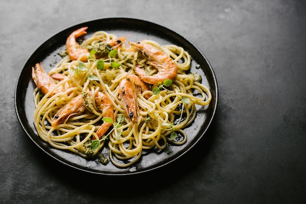 Espaguete com pesto e camarão servido na chapa