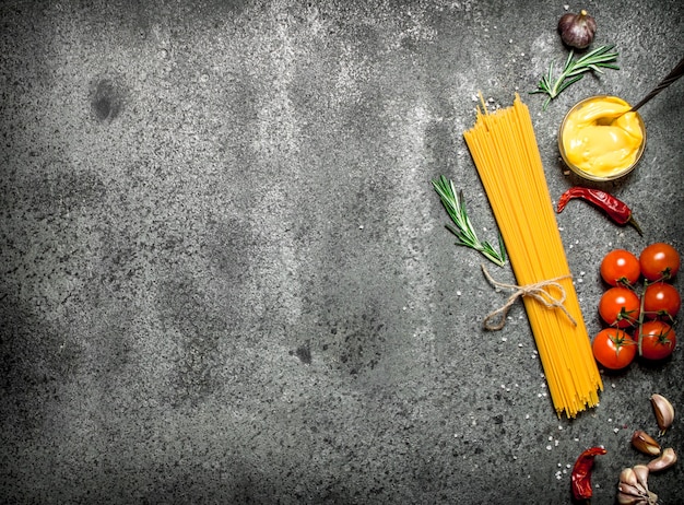 Espaguete com tomate, molho de mostarda e temperos em fundo rústico