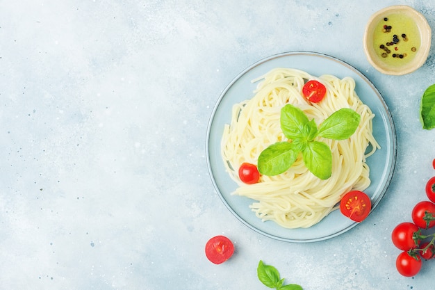 Espaguete cozido com tomate cereja em fundo cinza