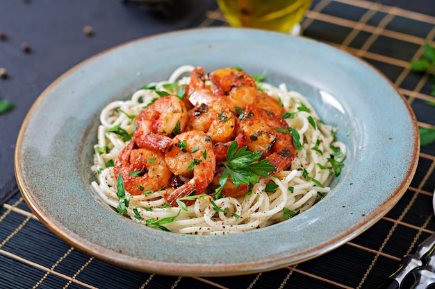 Espaguete da massa com camarões, tomate e salsa desbastada. comida saudável. refeição italiana.