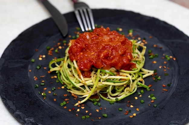 Foto espaguete de abobrinha com pimenta calabresa desidratada e molho vermelho.