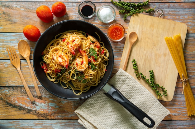 Espaguete De Camarão Mexa macarrão frito com legumes e camarão em uma frigideira de ferro preto com fundo de ardósia