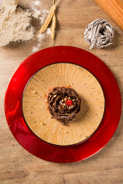 Espaguete de macarrão de chocolate cozido com molho de framboesa.