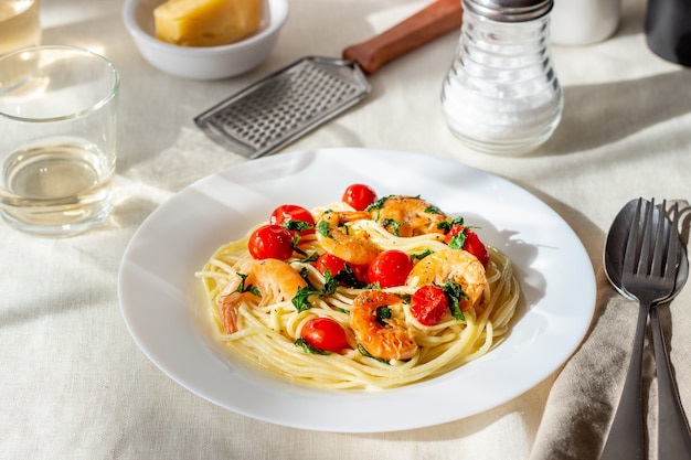 Foto espaguete de massa italiana com camarões e tomates. cozinha nacional.