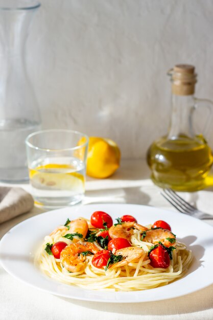 Foto espaguete de massa italiana com camarões e tomates. cozinha nacional.