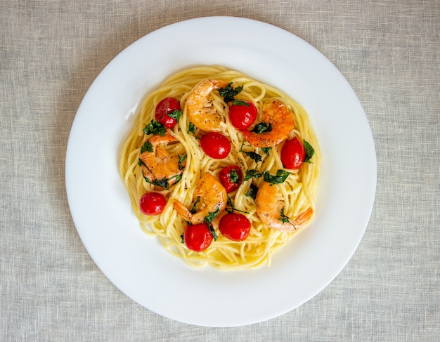 Espaguete de massa italiana com camarões e tomates. Cozinha nacional.