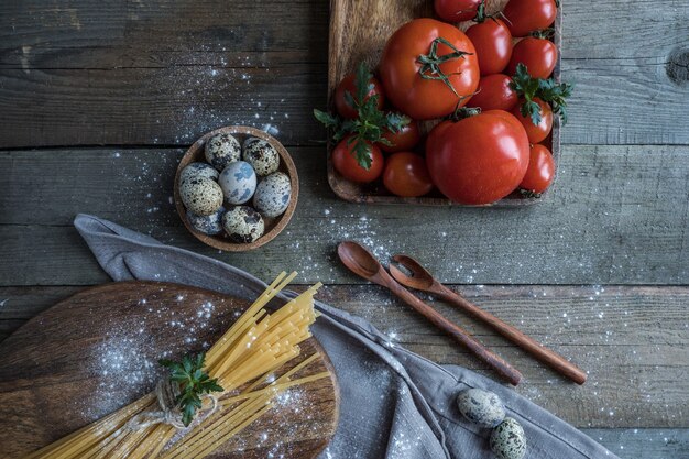 Espaguete de tomate e ovos sobre uma mesa de madeira polvilhada com farinha