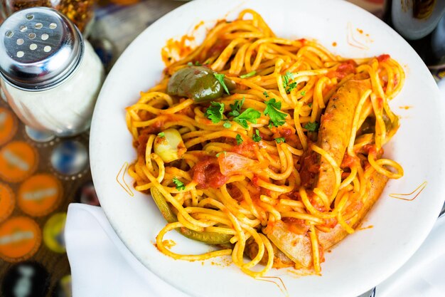 Espaguete fresco com salsicha, pimentão e cebola no restaurante italiano.