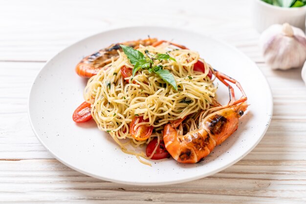 Espaguete frito com camarão grelhado e tomate