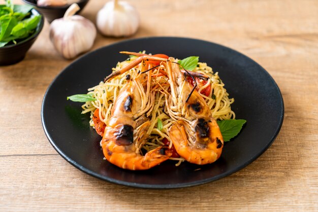 Espaguete frito com camarão grelhado e tomate