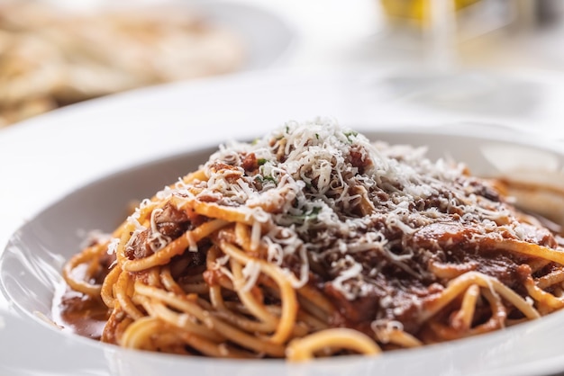 Foto espaguete italiano tradicional com molho vermelho polvilhado com parmesão ralado na hora
