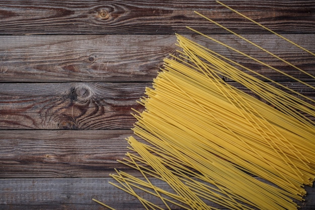 Espaguete longo amarelo sobre fundo preto. Espaguete cru.